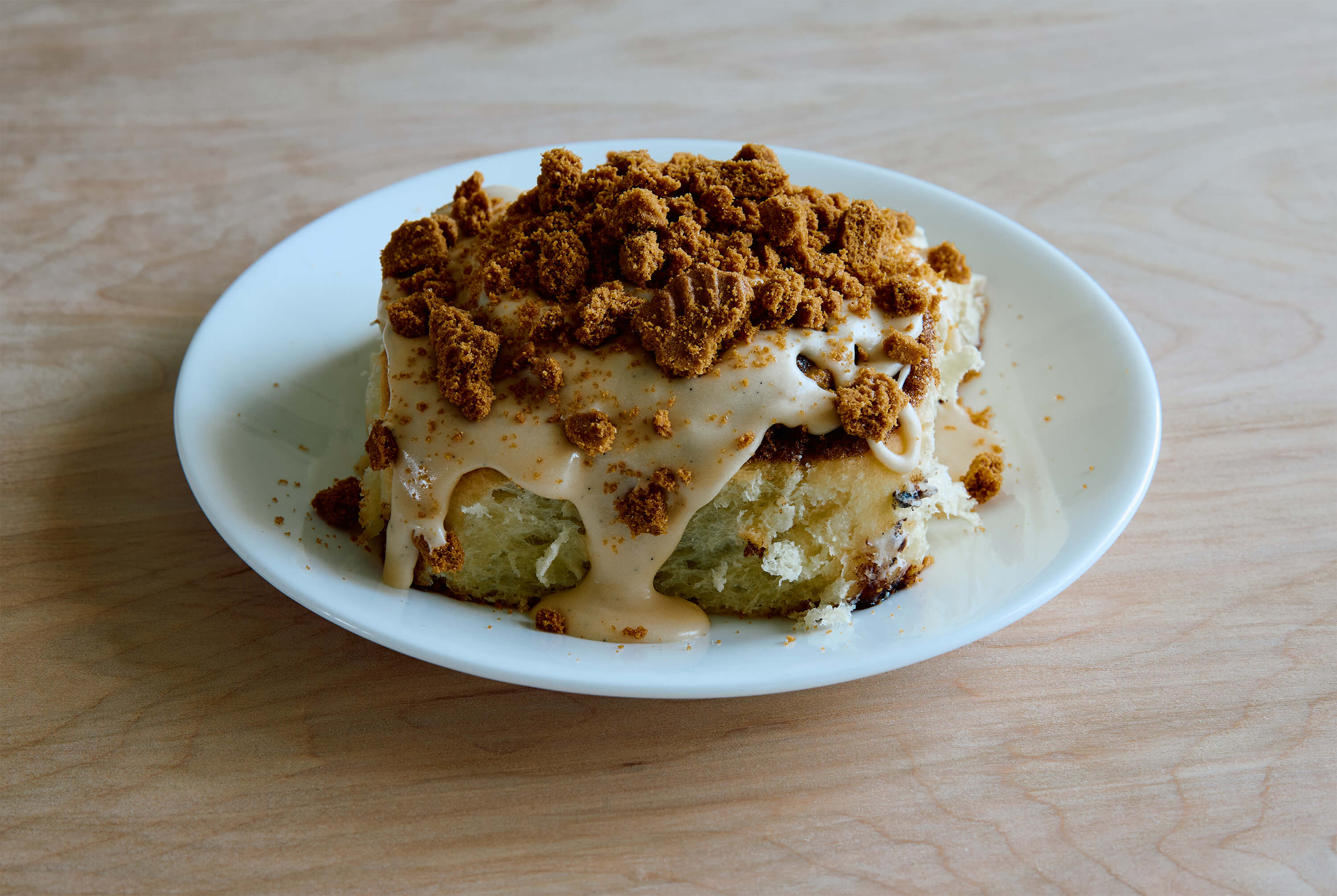 classic cinnamon roll with biscoff cookie butter frosting and crushed biscoff cookie pieces
